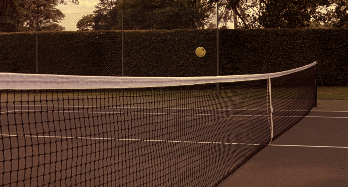 a ball hovers over the tennis net